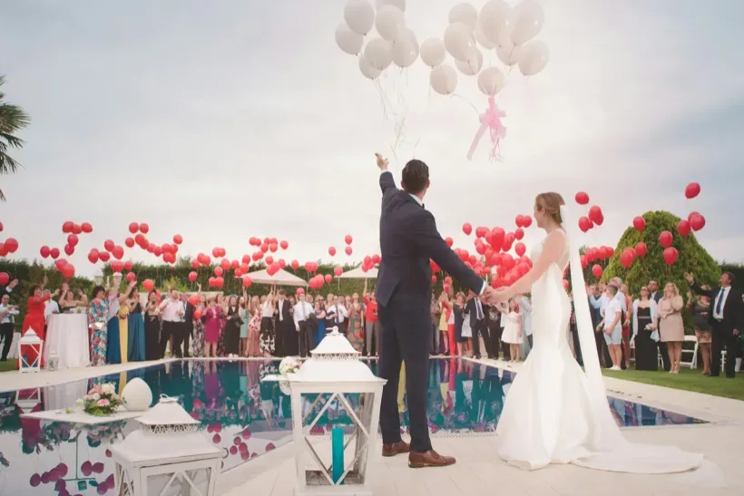 Newly married couple walking through a flower-lined wedding ceremony